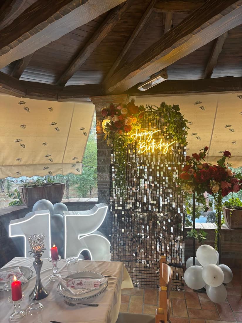 Birthday setup with a giant light-up number 15 and balloons