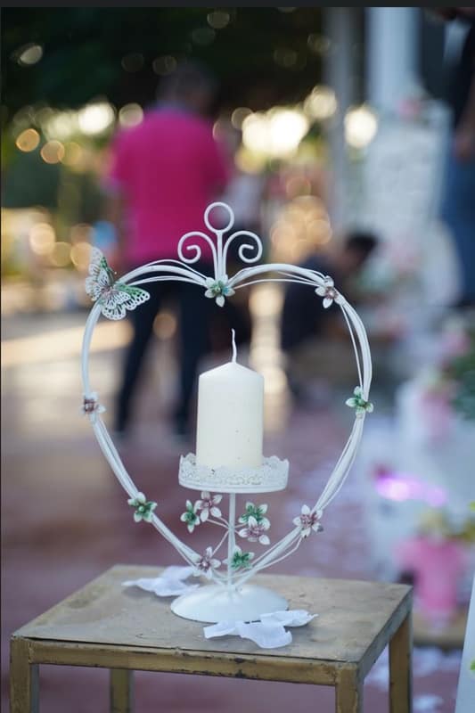 White candle inside a wire heart holder