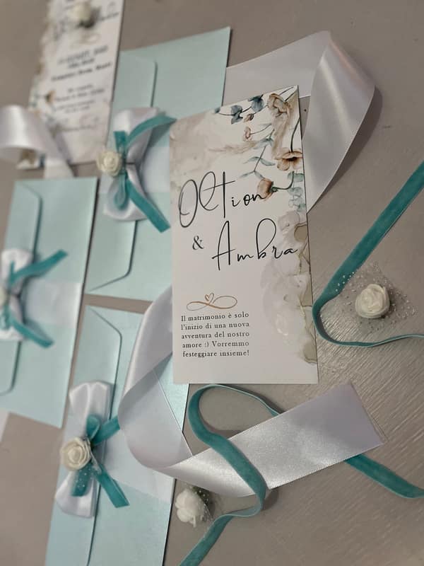 Invitations tied with teal ribbon