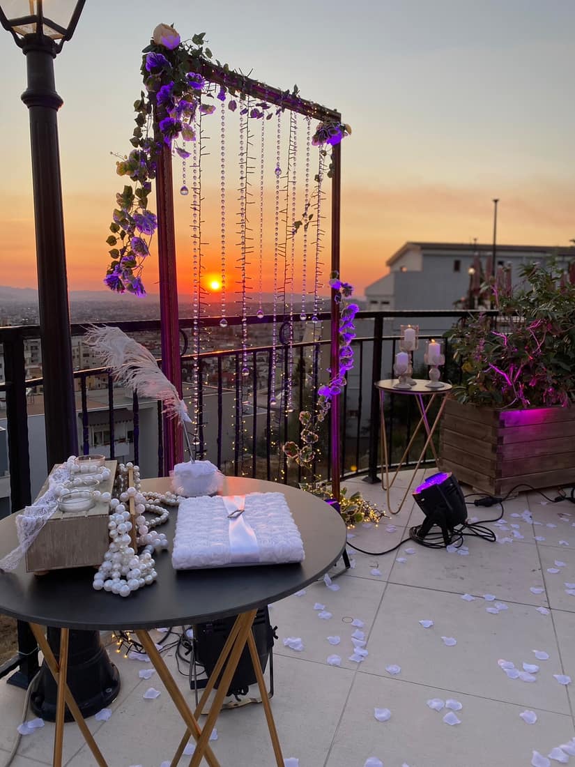Terrace decorated with flowers and hanging lights at sunset